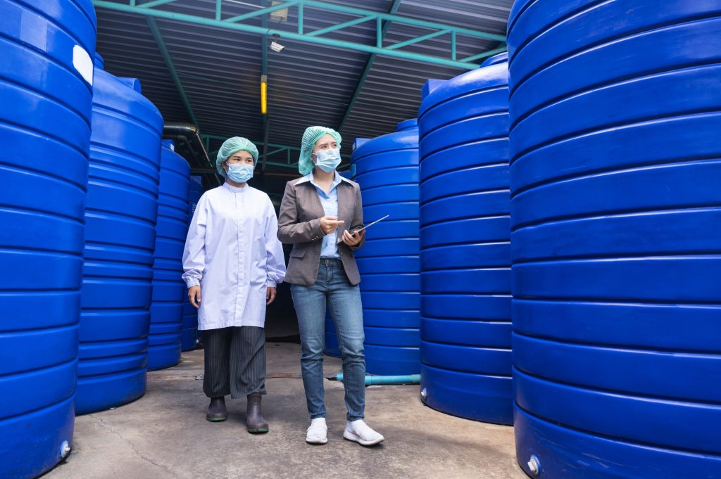 Asian inspector supervisor woman and assistant employeeto checking stock of water tank